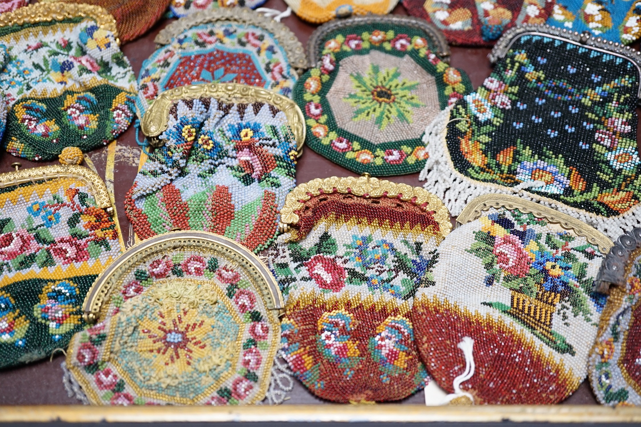 Twenty mid-19th century Berlin beadwork purses with gilt-metal frames, largest 10cm